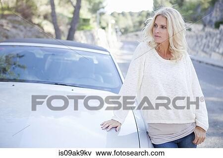 Stock Photo - Woman beside her convertible car. Fotosearch