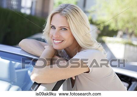 Woman beside her convertible car View Large Photo Image Stock Photograph - Woman beside her convertible car. Fotosearch