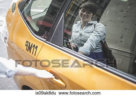 Woman getting into yellow taxi, New York, US View Large Photo Image Stock Photograph - Woman getting into yellow taxi, New York, US. Fotosearch