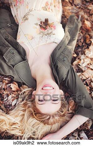 Woman lying on autumn leaves View Large Photo Image Stock Image - Woman lying on autumn leaves. Fotosearch