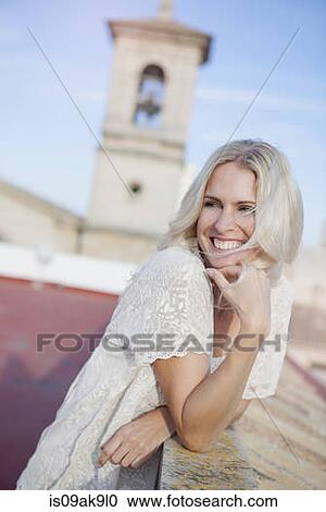 Stock Image - Woman on rooftop, bell tower in background. Fotosearch