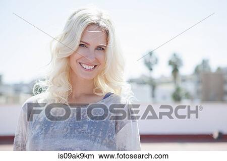 Woman on rooftop, town below in background View Large Photo Image Picture - Woman on rooftop, town below in background. Fotosearch