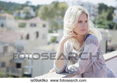Woman on rooftop, town below in background View Large Photo Image Picture - Woman on rooftop, town below in background. Fotosearch