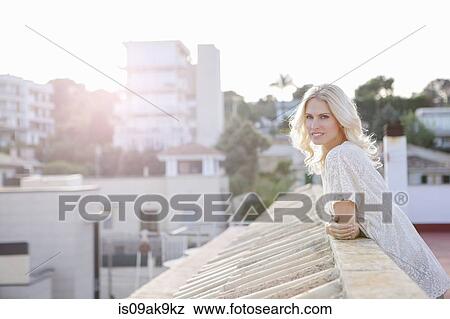Stock Photo - Woman on rooftop, town below in background. Fotosearch