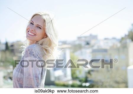 Woman on rooftop, town below in background View Large Photo Image Stock Photography - Woman on rooftop, town below in background. Fotosearch