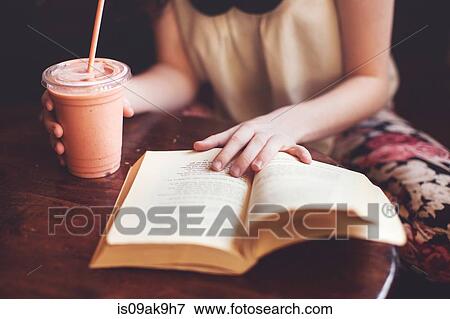 Woman reading book on table View Large Photo Image Stock Photo - Woman reading book on table. Fotosearch