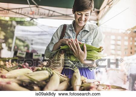 Stock Photo - Woman shopping at vegetable market. Fotosearch