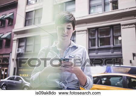 Woman using smartphone on street, New York, US View Large Photo Image Picture - Woman using smartphone on street, New York, US. Fotosearch