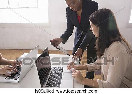 Women using laptop and digital tablet View Large Photo Image Stock Image - Women using laptop and digital tablet. Fotosearch