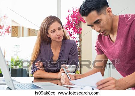 Worried couple checking bills and paperwork in dining room View Large Photo Image Stock Image - Worried couple checking bills and paperwork in dining room. Fotosearch