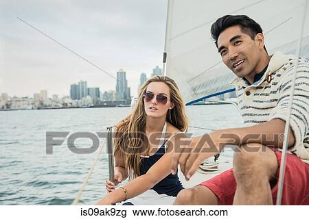 Stock Image - Young couple on sailing boat. Fotosearch