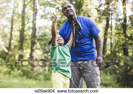 Young father and daughter bird watching in forest eco camp View Large Photo Image Picture - Young father and daughter bird watching in forest eco camp. Fotosearch