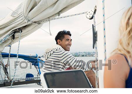 Young man on sailing boat, laughing View Large Photo Image Stock Image - Young man on sailing boat, laughing. Fotosearch