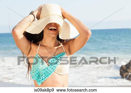 Young woman holding onto her sunhat on beach, Malibu, California, USA View Large Photo Image Stock Photo - Young woman holding onto her sunhat on beach, Malibu, California, USA. Fotosearch