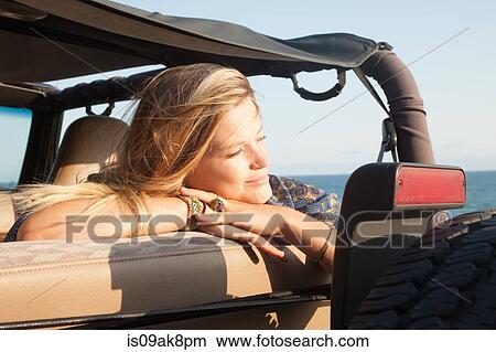 Young woman leaning on jeep window at coast, Malibu, California, USA View Large Photo Image Picture - Young woman leaning on jeep window at coast, Malibu, California, USA. Fotosearch