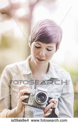 Picture - Young woman looking at her camera. Fotosearch