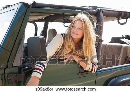 Stock Photography - Young woman looking out of jeep window. Fotosearch