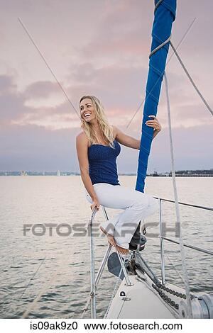 Young woman sitting on railing on sailing boat View Large Photo Image Stock Image - Young woman sitting on railing on sailing boat. Fotosearch