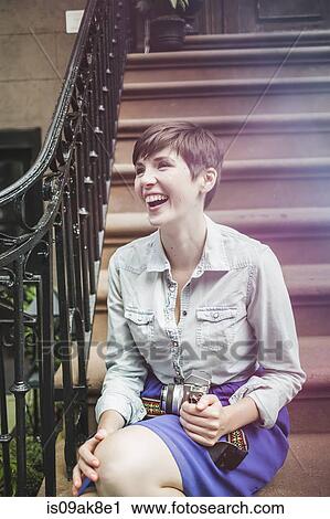 Young woman sitting on steps with camera, New York, US View Large Photo Image Stock Image - Young woman sitting on steps with camera, New York, US. Fotosearch