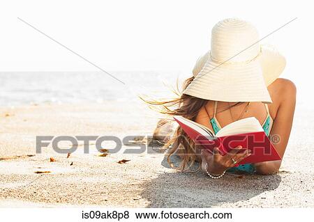 Young woman sunbathing and reading book on beach, Malibu, California, USA View Large Photo Image Stock Photo - Young woman sunbathing and reading book on beach, Malibu, California, USA. Fotosearch