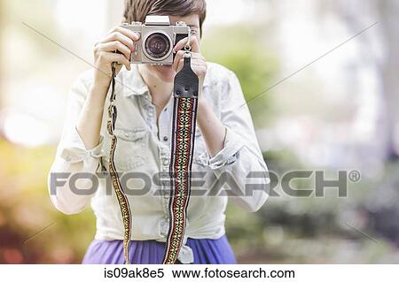 Young woman taking a photograph View Large Photo Image Stock Photography - Young woman taking a photograph. Fotosearch