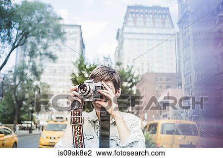 Young woman taking a picture, New York, US View Large Photo Image Stock Image - Young woman taking a picture, New York, US. Fotosearch