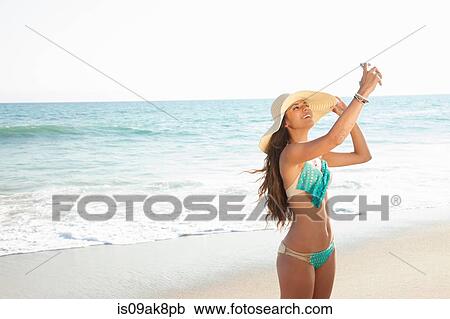 Young woman taking selfie on smartphone on beach, Malibu, California, USA View Large Photo Image Stock Image - Young woman taking selfie on smartphone on beach, Malibu, California, USA. Fotosearch