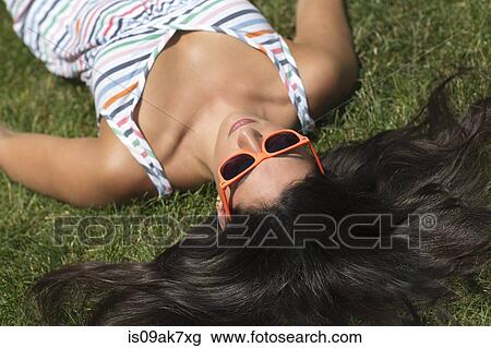Young woman wearing sundress sunbathing on lawn View Large Photo Image Stock Image - Young woman wearing sundress sunbathing on lawn. Fotosearch