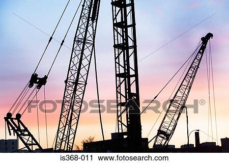 Construction cranes at sunset View Large Photo Image Stock Image - Construction cranes at sunset. Fotosearch