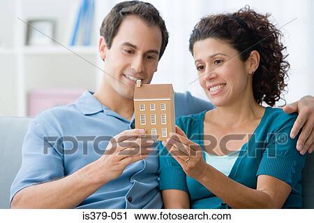 Stock Image - Couple holding a model of a house. Fotosearch