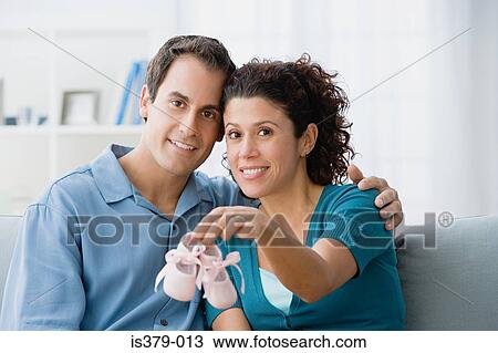 Stock Image - Couple holding a pair of baby booties. Fotosearch