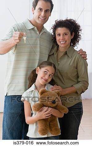 Family holding keys to new house View Large Photo Image Stock Photograph - Family holding keys to new house. Fotosearch