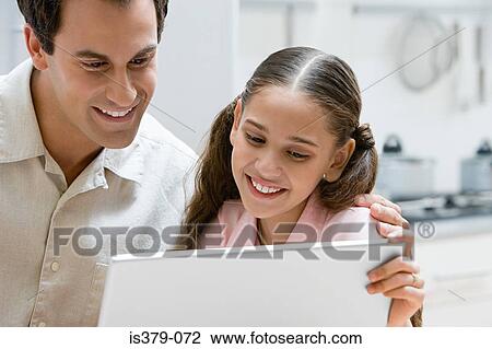 Father and daughter using a laptop computer View Large Photo Image Stock Image - Father and daughter using a laptop computer. Fotosearch