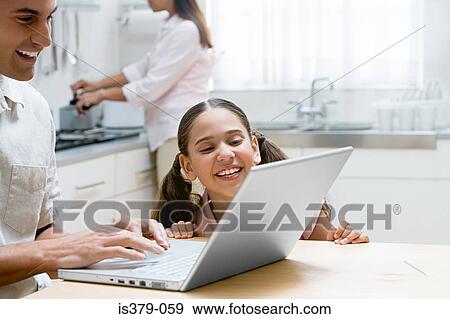 Father and daughter using a laptop computer View Large Photo Image Stock Photo - Father and daughter using a laptop computer. Fotosearch