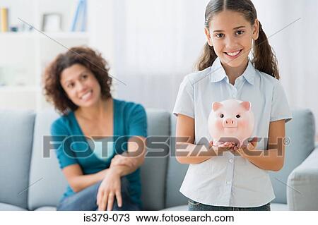 Girl holding a piggy bank View Large Photo Image Stock Image - Girl holding a piggy bank. Fotosearch