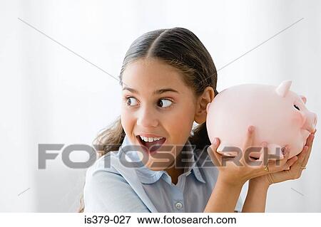 Stock Photo - Girl holding a piggy bank. Fotosearch