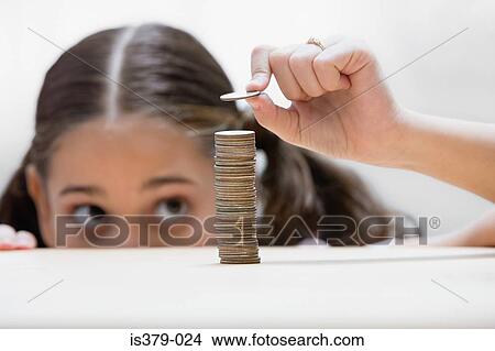 Girl placing a coin on stack View Large Photo Image Picture - Girl placing a coin on stack. Fotosearch