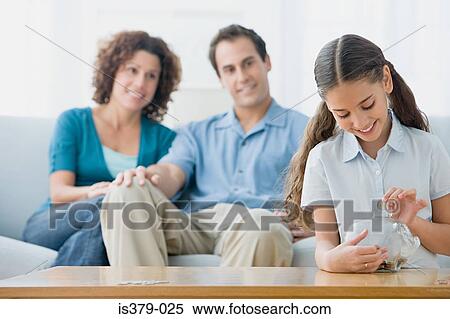 Girl putting coins in a piggy bank View Large Photo Image Stock Photography - Girl putting coins in a piggy bank. Fotosearch