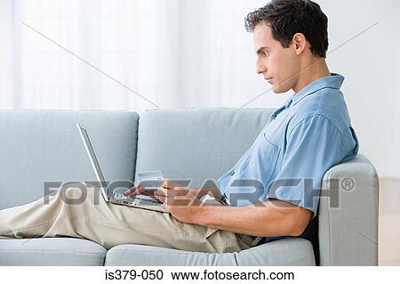 Man using a laptop computer at home View Large Photo Image Stock Image - Man using a laptop computer at home. Fotosearch