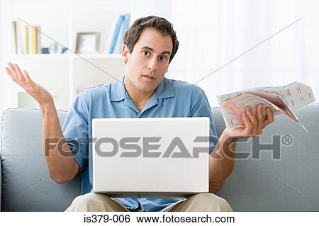 Man with bills and a laptop computer View Large Photo Image Stock Photograph - Man with bills and a laptop computer. Fotosearch