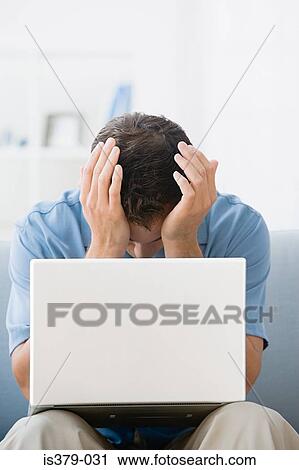 Stock Image - Man with his head in hands. Fotosearch