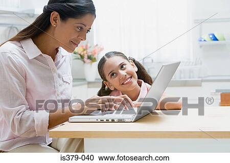 Stock Image - Mother and daughter using a laptop computer. Fotosearch