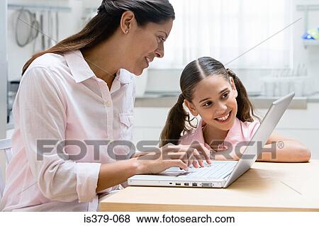 Mother and daughter using a laptop computer View Large Photo Image Stock Photo - Mother and daughter using a laptop computer. Fotosearch