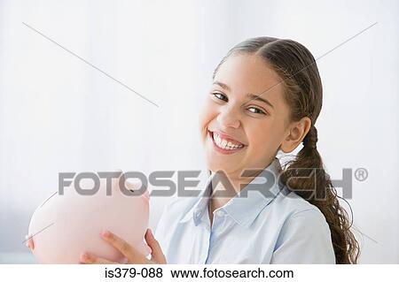 Stock Photo - Smiling girl holding a piggy bank. Fotosearch