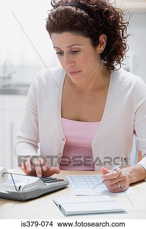Woman looking at home finances View Large Photo Image Picture - Woman looking at home finances. Fotosearch