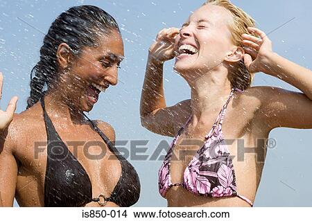 Two women getting splashed with water View Large Photo Image Picture - Two women getting splashed with water. Fotosearch