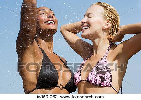 Two women gettting splashed with water View Large Photo Image Stock Image - Two women gettting splashed with water. Fotosearch