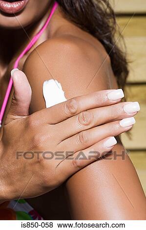 Woman applying sun cream View Large Photo Image Stock Photo - Woman applying sun cream. Fotosearch