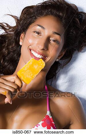 Woman eating ice lolly View Large Photo Image Stock Photo - Woman eating ice lolly. Fotosearch