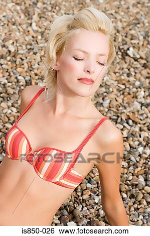 Stock Photograph - Woman relaxing on beach. Fotosearch